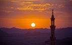 Puesta de sol sobre el desierto con el minarete de una mezquita en primer plano. Foto: Magnific - @nikitabuida