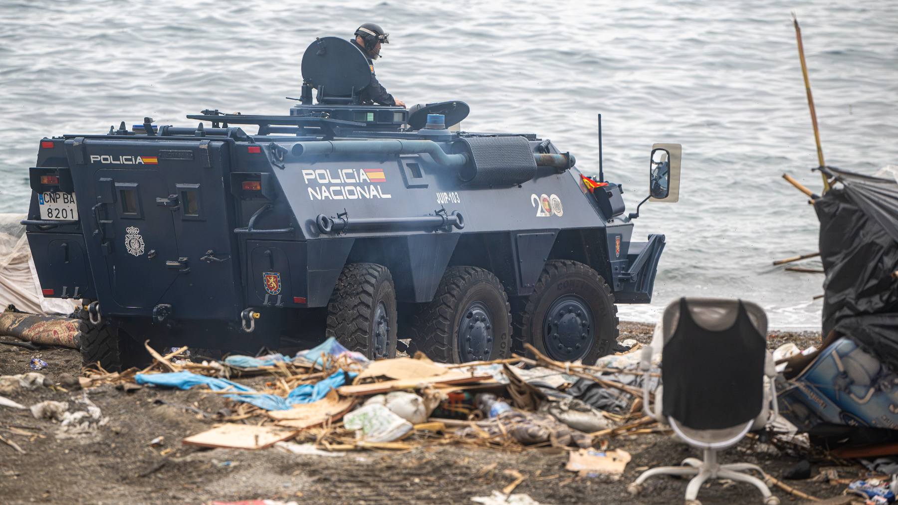 Agentes de la Policía Nacional intervienen durante el proceso de desalojo del embolsamiento de inmigrantes en la playa de El Trampolín. (Foto: Europa Press).