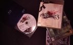 Disco de un juego de PS3 junto a un lector Blu-ray para el emulador RPCS3