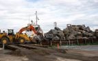 Rocas de granito noruego apiladas en una barcaza en el puerto de Teesside
