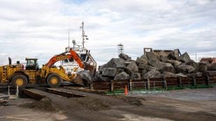 Rocas de granito noruego apiladas en una barcaza en el puerto de Teesside