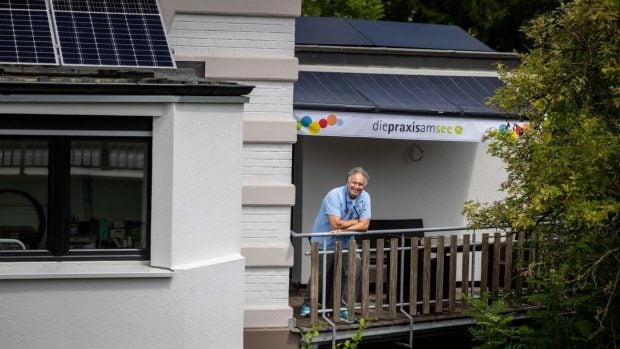 El pediatra Tobias Gregor, en el balcón de su consulta de Essen, en Alemania, bajo el toldo solar con células fotovoltaicas integradas en la lona. Foto: SolarMarkise / WAZ
