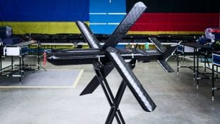 Un dron Seth X en la nave de producción de Auterion con las banderas de Ucrania y Alemania al fondo