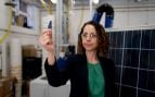 La profesora Mahshid Firouzi sostiene un fragmento de célula de paneles solares retirados