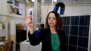 La profesora Mahshid Firouzi sostiene un fragmento de célula de paneles solares retirados