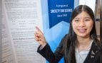 Rachel Chen señala su póster de diagramas en la final de la Regeneron Science Talent Search 2026