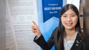 Rachel Chen señala su póster de diagramas en la final de la Regeneron Science Talent Search 2026