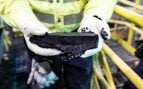 Un operario sostiene la torta de telururo de cobre de la planta de Kennecott, en Utah