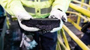 Un operario sostiene la torta de telururo de cobre de la planta de Kennecott, en Utah