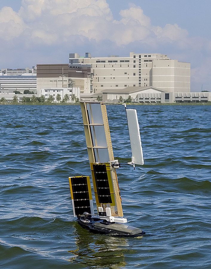 El robot velero ALBATROSS navegando con sus alas-vela levantadas en un embalse de Singapur