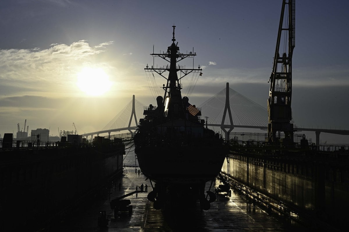 El destructor Arleigh Burke a contraluz dentro del dique seco de Navantia en Cádiz, con un puente atirantado al fondo