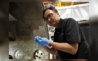 Yi Lin, de NASA Langley, sostiene una pila de botón de las baterías de estado sólido SPEARS tras la prueba de vacío térmico