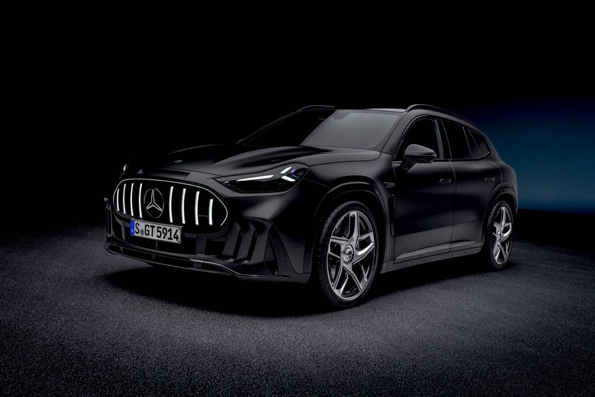 Vista frontal en tres cuartos del Mercedes-AMG GT SUV negro con la parrilla iluminada, en un estudio oscuro