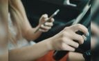 Conductora con el móvil al volante en la imagen de la nota de la DGT sobre su campaña de distracciones