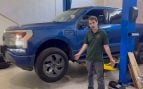 Ford F-150 Lightning Lariat azul en el elevador del taller WattWorks junto al mecánico Alex Bessinger