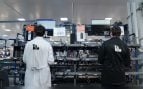 Dos operarios de Yadro ante los bancos de equipos de la planta de Dubna, que fabrica estaciones base para el 5G en Rusia