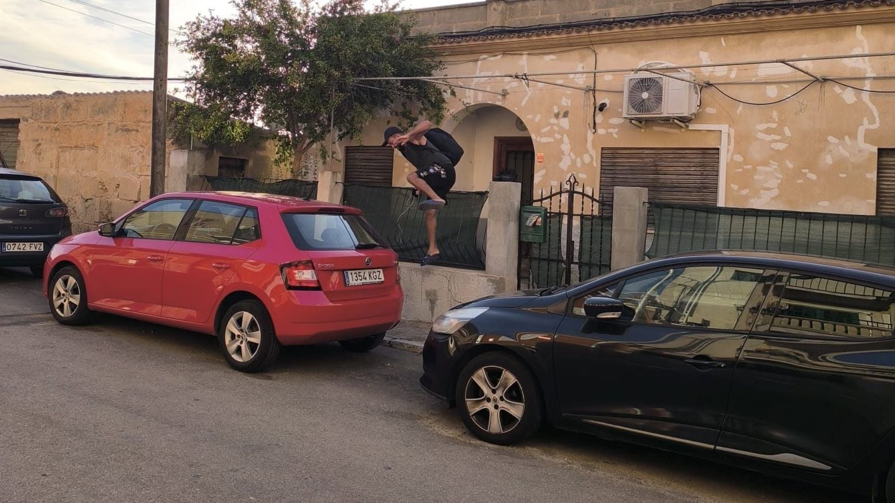 Uno de los jóvenes delinccuentes saltando la valla de una vivienda.