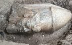 Cabeza de granito de una estatua con corona, todavía semienterrada en el pozo de excavación. Foto: Ministerio de Turismo y Antigüedades de Egipto