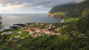 Vista del pueblo de Fajã Grande, en la isla de Flores, entre el océano Atlántico y un acantilado verde