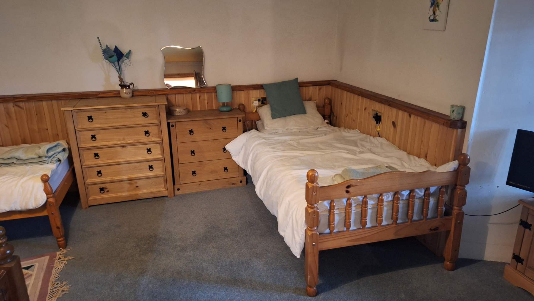 Habitaci&oacute;n compartida del castillo Hallgreen con dos camas individuales de madera, c&oacute;modas y moqueta gris