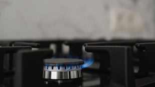 Hornalla de una cocina de gas encendida, con la llama azul del gas natural. Foto: Magnific - @ededchechine