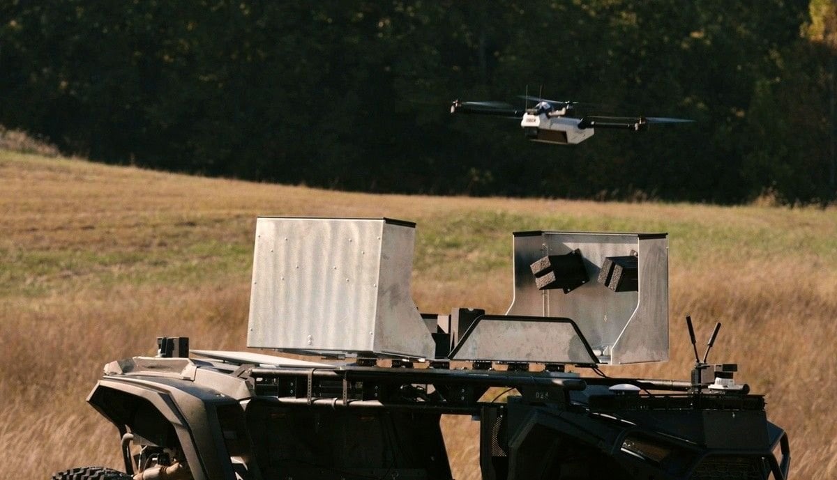 Un dron de Anduril vuela sobre un veh&iacute;culo aut&oacute;nomo de Overland AI con cajas met&aacute;licas en Fort Knox