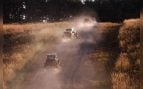 Vehículos autónomos del programa RACER de DARPA avanzan en fila por un camino de tierra en el campo de tiro St. Vith de Fort Knox
