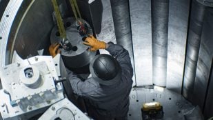 Técnico de Antares con casco y guantes montando piezas del reactor Mark-0, antecesor del microrreactor Mark-1