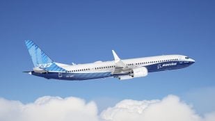 Boeing 737-10, el mayor avión de la familia 737 MAX, en vuelo sobre las nubes con la librea azul de Boeing