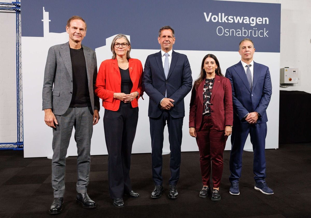 Firmantes del acuerdo sobre la fábrica de Volkswagen de Osnabrück ante el cartel de la planta