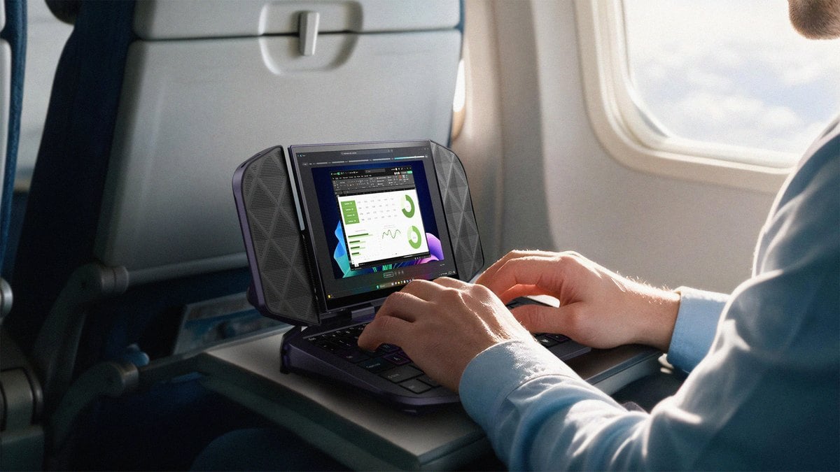 Un pasajero escribe con el teclado del Project DualPlay Mini abierto sobre la bandeja de un avi&oacute;n