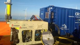 El robot submarino Étaín de la Universidad de Limerick, un ROV Comanche, en la cubierta de un barco junto a un parque eólico marino