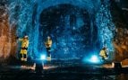 Tres técnicos de Posiva con ropa reflectante trabajan en una galería excavada en la roca del almacén de combustible nuclear gastado de Onkalo