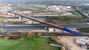 Tablero de acero del viaducto HS2 deslizándose sobre la autopista M6 con tráfico circulando por debajo, cerca de Birmingham