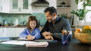 Un padre y una hija haciendo los deberes - Canva