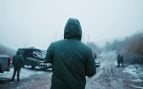 Siembra de nubes con drones: un técnico de Rainmaker, de espaldas, lleva un dron en las manos bajo la nieve