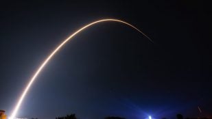 Estela de un cohete Falcon 9 con satélites Starlink en el cielo nocturno, imagen ligada a Starlink Mobile
