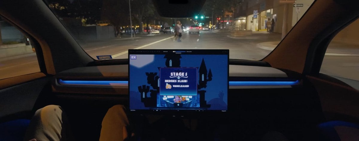 Vista nocturna de una calle desde el interior de un veh&iacute;culo de Tesla con pantalla central