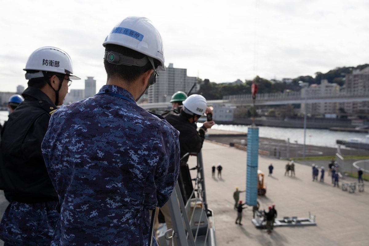 Contenedor azul colgado de una gr&uacute;a en el muelle de Yokosuka durante la demostraci&oacute;n de recarga del Mk 41 del USS Ralph Johnson