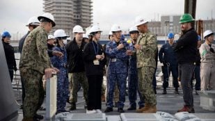Marinos de EEUU y de la JMSDF conversan sobre la cubierta del USS Ralph Johnson durante la demostración de recarga del Mk 41