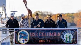 Responsables del astillero y de la dotación del submarino USS Columbia (SSN 771) con el cartel del buque a su llegada a Portsmouth Naval Shipyard