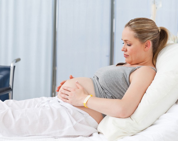 Pregnant young woman on a hospital bed