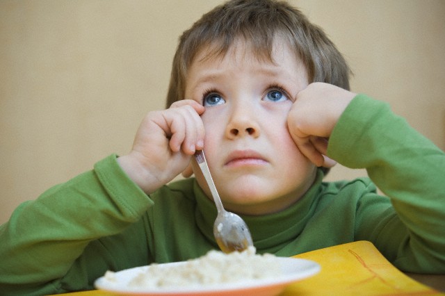Portrait young boy gazing upwards while eating