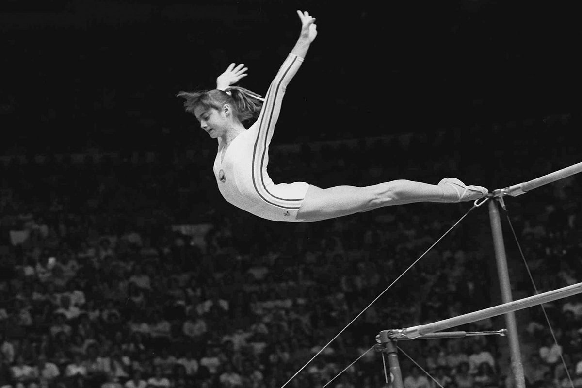 Nadia Comaneci, of Romania, dismounts from the uneven parallel bars at the Olympic Games in Montreal