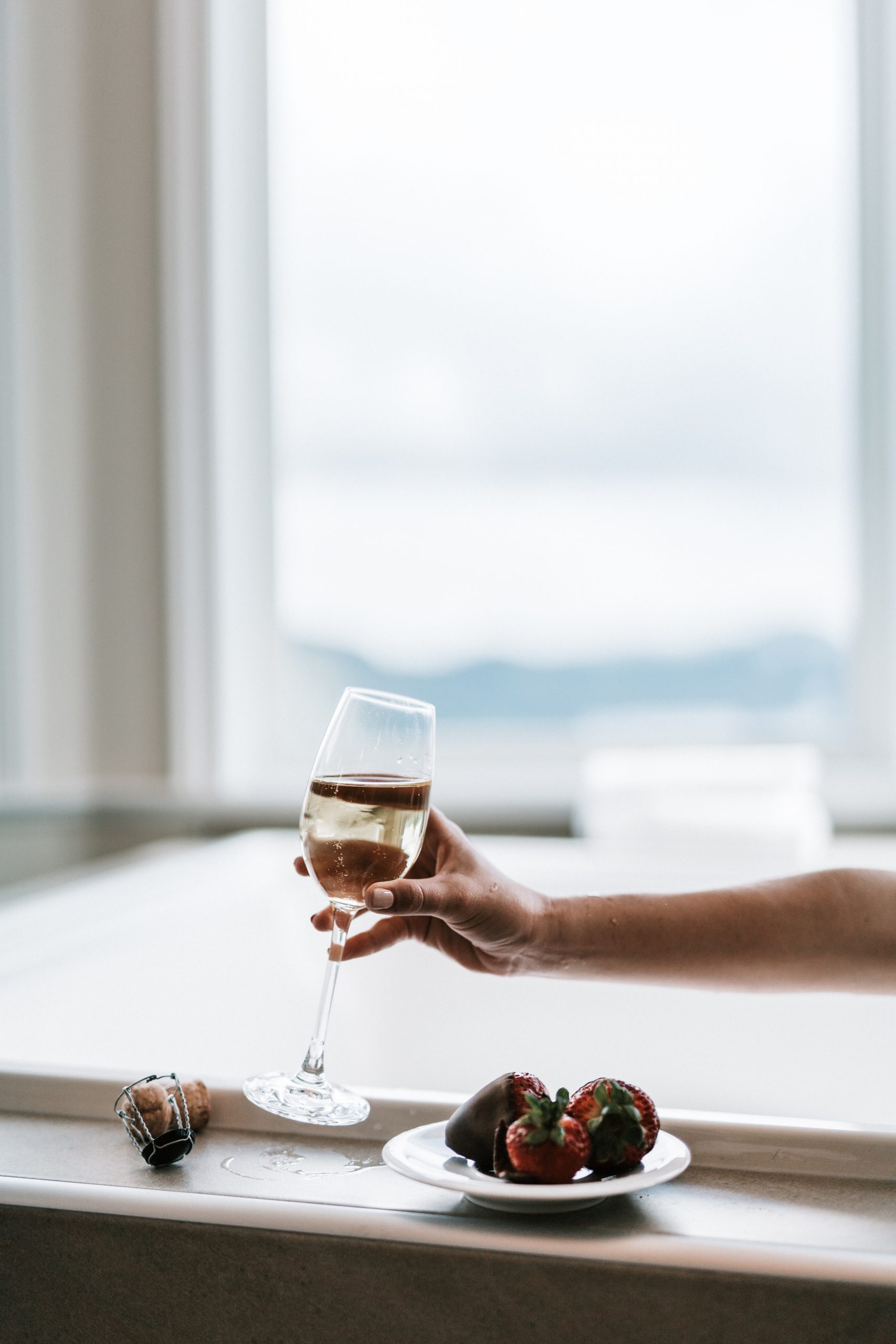 En la foto, una copa de vino y fresas con chocolate. /Foto: Pexels