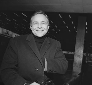 En la imagen, Marlon Brando en los años 60 con abrigo y jersey de cuello alto./Foto: Getty
