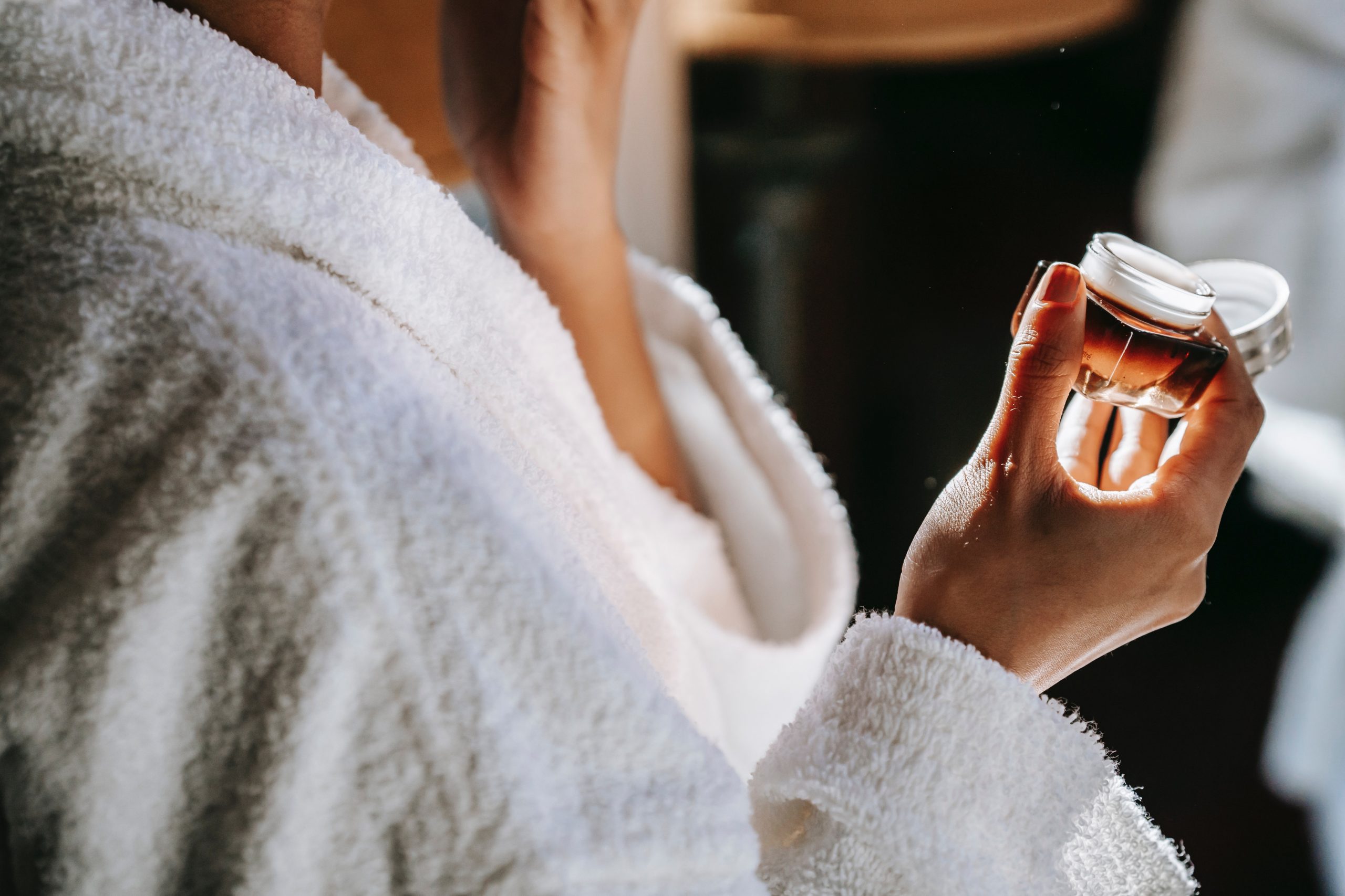 Una mujer ech&aacute;ndose crema / Foto: Pexels