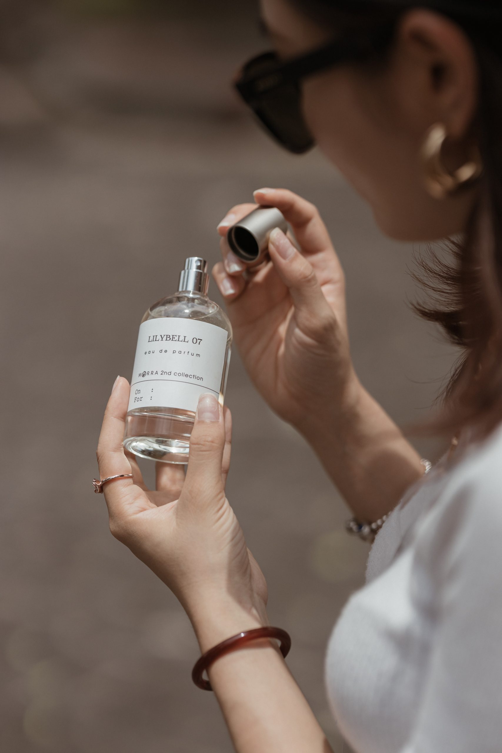 Una chica sostiene un perfume/Foto: Unsplash