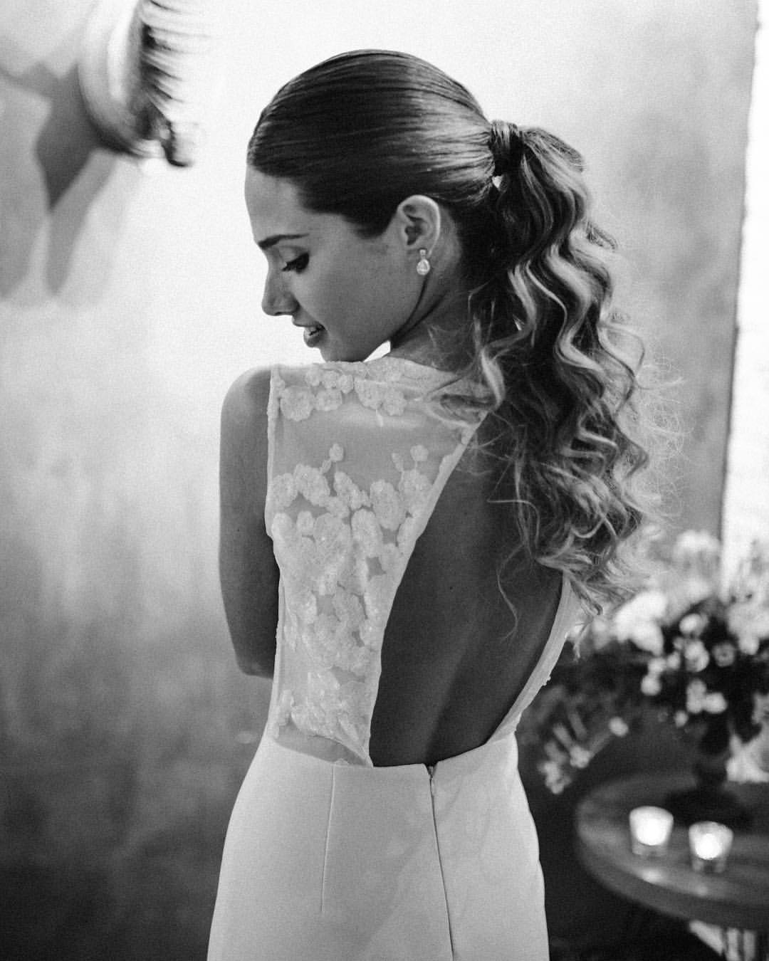 Peinado de novia con coleta rizada.