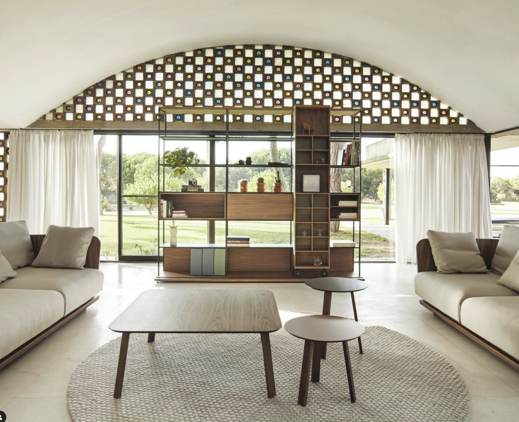 Sal&oacute;n de dise&ntilde;o biof&iacute;lico con grandes ventanales.